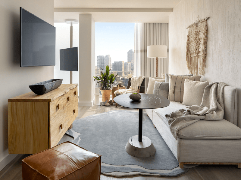 Narrow living room area with high coffee table and wooden dresser