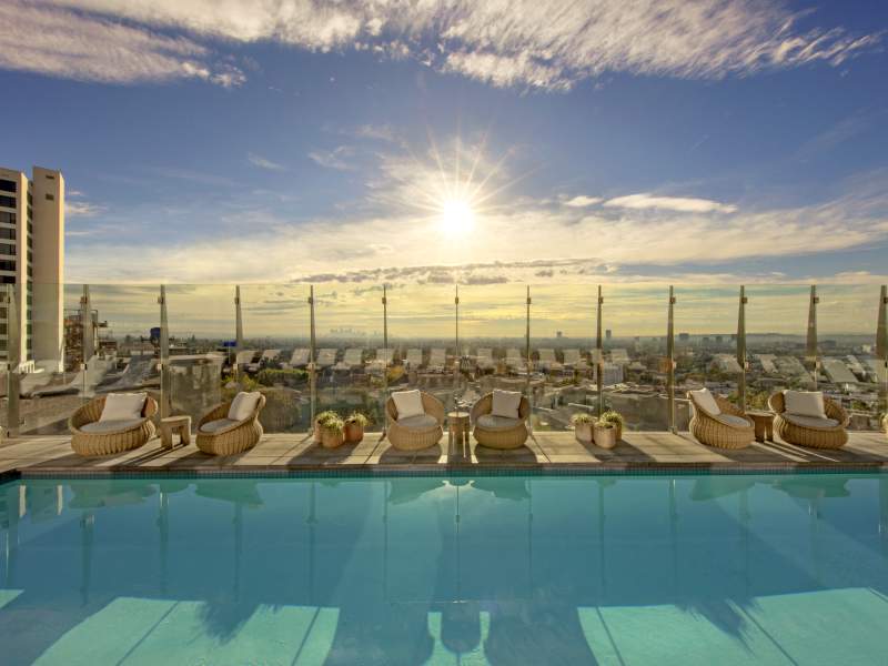 Patio au bord de la piscine avec vue sur la ville en contrebas