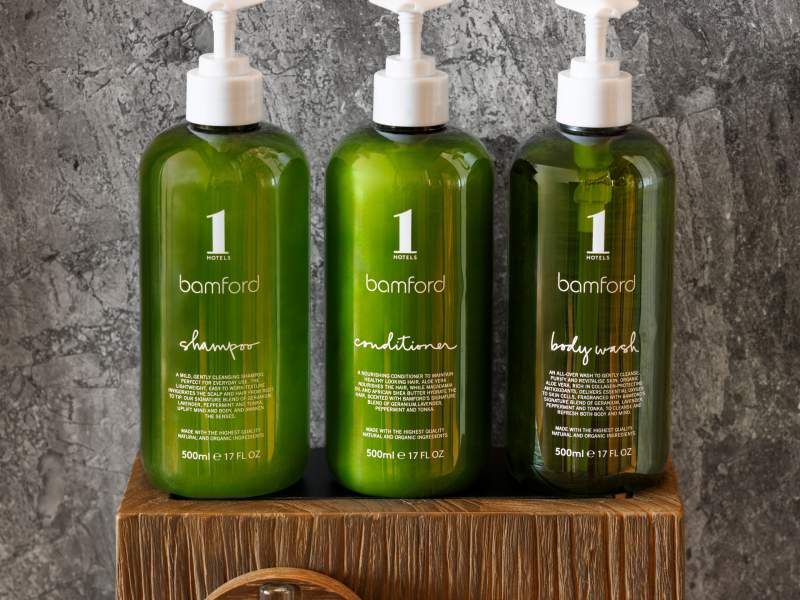 green bottles of shampoo on a wooden block