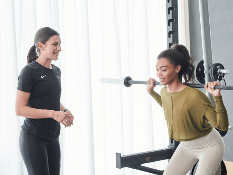 Personal trainer working with someone doing a squat