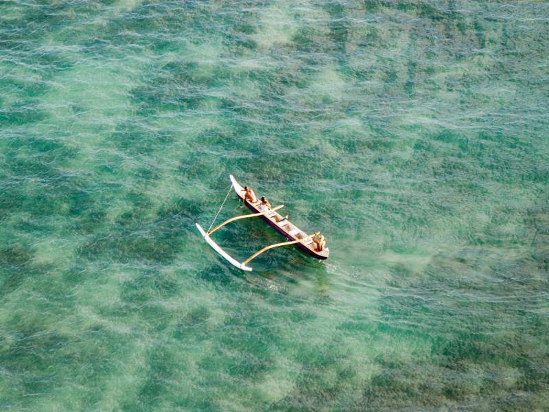 Personnes sur un outrigger sur l'eau
