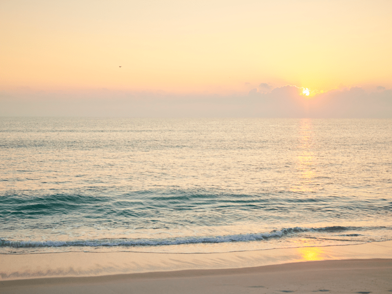 Waves crashing on a beach at sunset