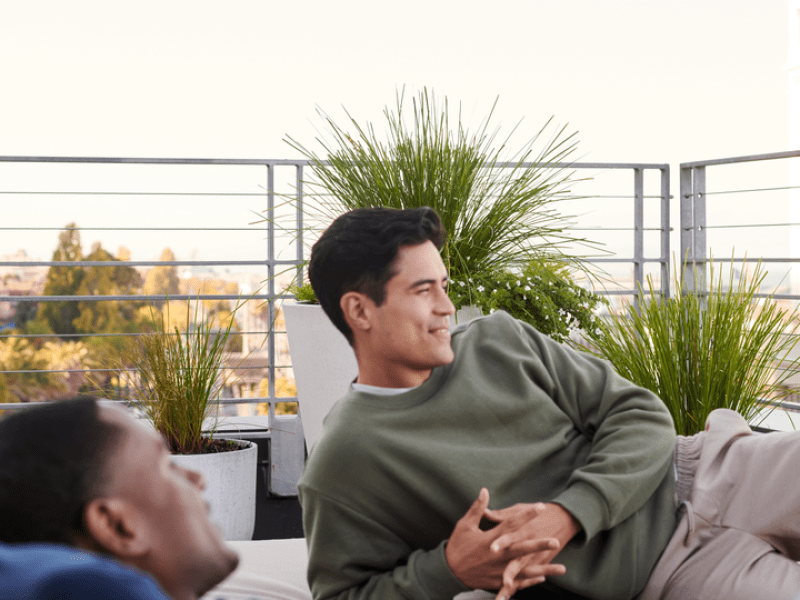 Two men lounging outside on their patio