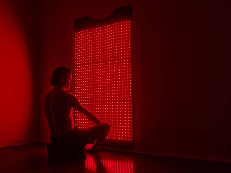 postura de ioga em frente à terapia de luz vermelha