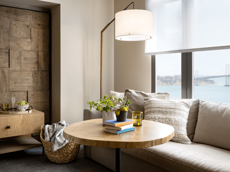 A sofa nestled into the corner of a room near the window offers space for relaxation