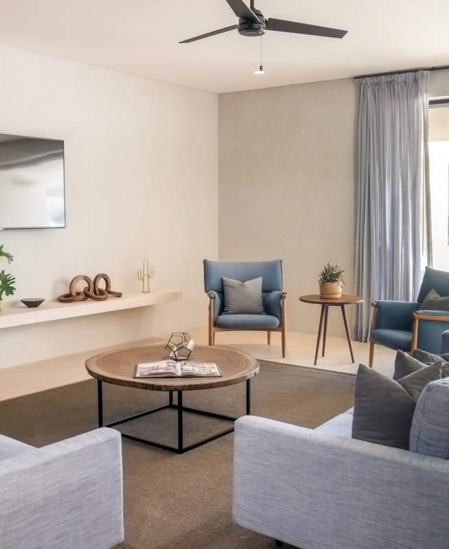 A large suite with two sofas facing a television complete with a private outdoor patio overlooking the ocean