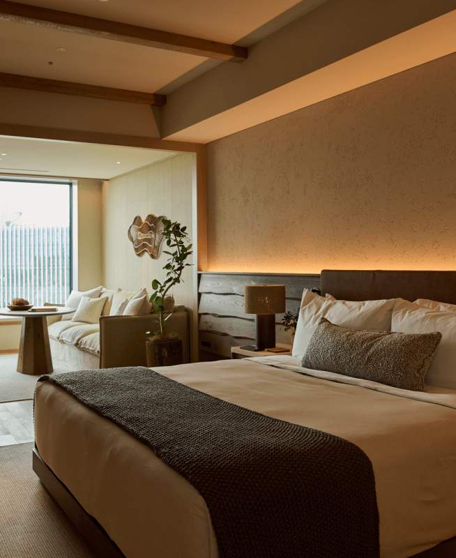 Camera con letto king size, poltrona vicino alla finestra con vista sulla città di Tokyo