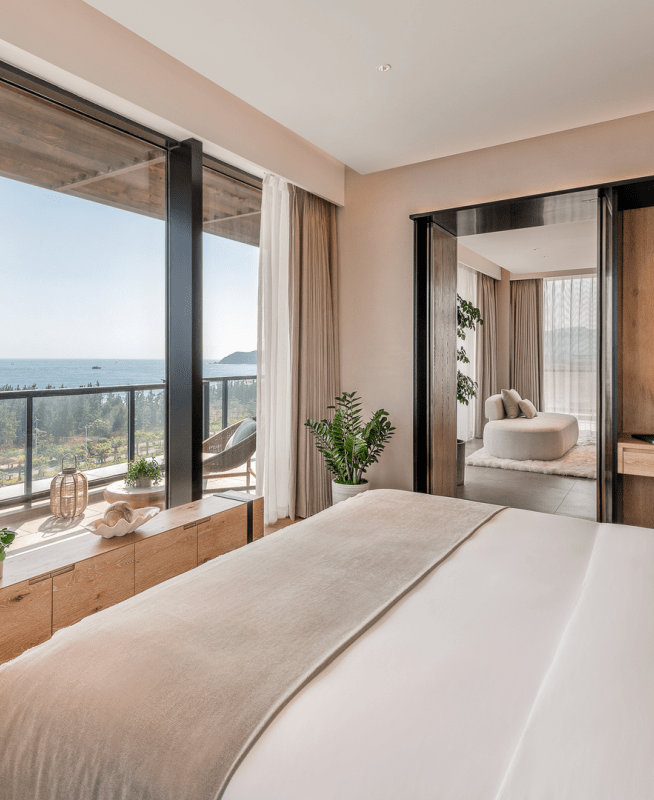 A bed facing the window which looks out to the ocean