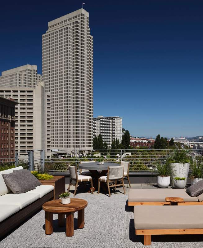 Patio sofa and reclined lounge chairs furnish the Ferry House suite with views of the Ferry Building in the distance to the right