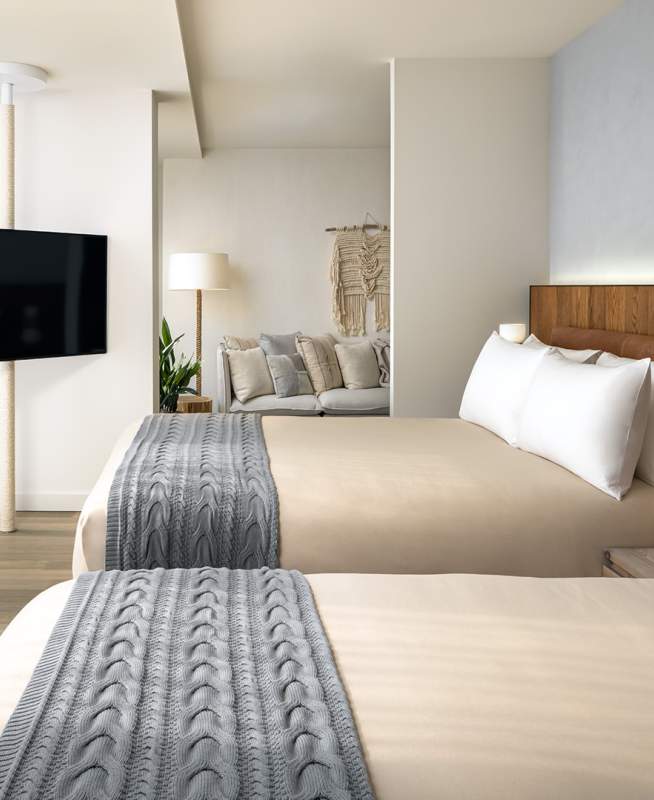 A room with two queen size beds and a television