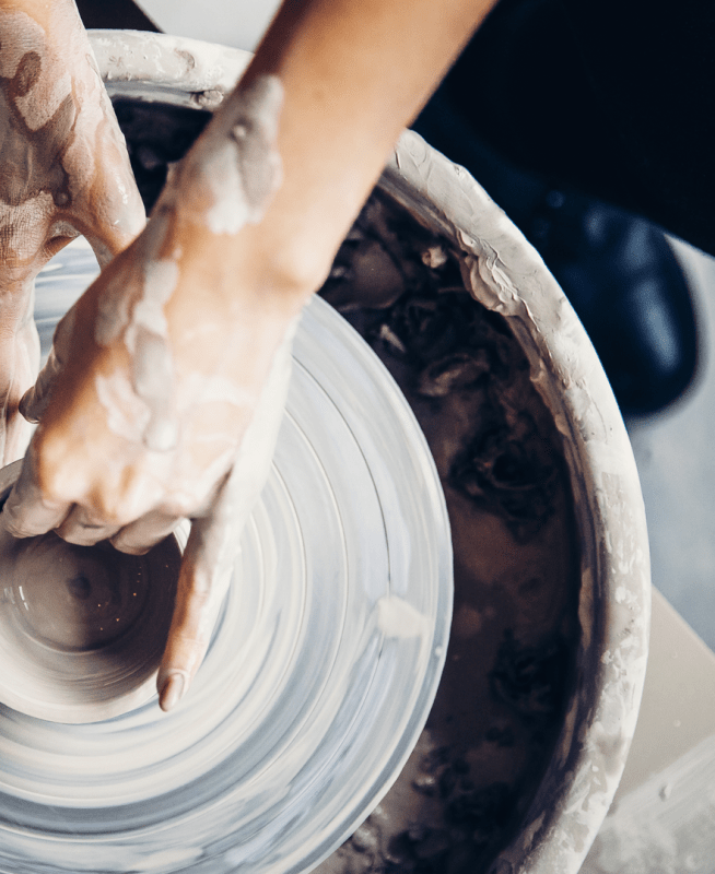 hands shaping pottery on a pottery wheel