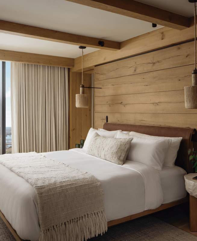 Large Bed in wooden interior with large window