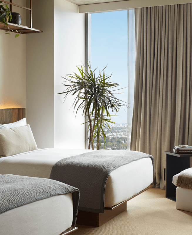 Two beds side by side with views of the city 