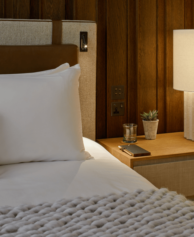 Bedside table with a lamp and potted plant