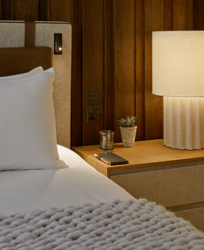 Bedside table with a lamp and potted plant