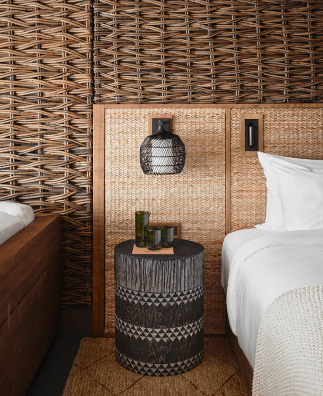 A decorative side table sits in front of a rustic wooden backdrop