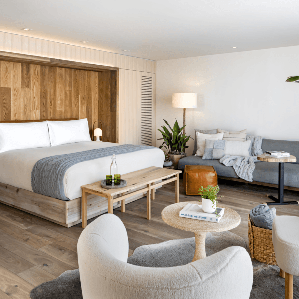 A king size bed with a sofa to the right and dual seating with a coffee table to the left