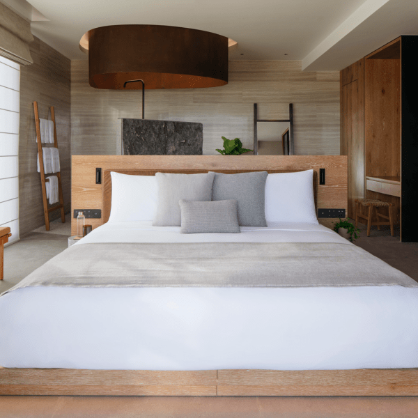 A made bed in the ocean pool view suite