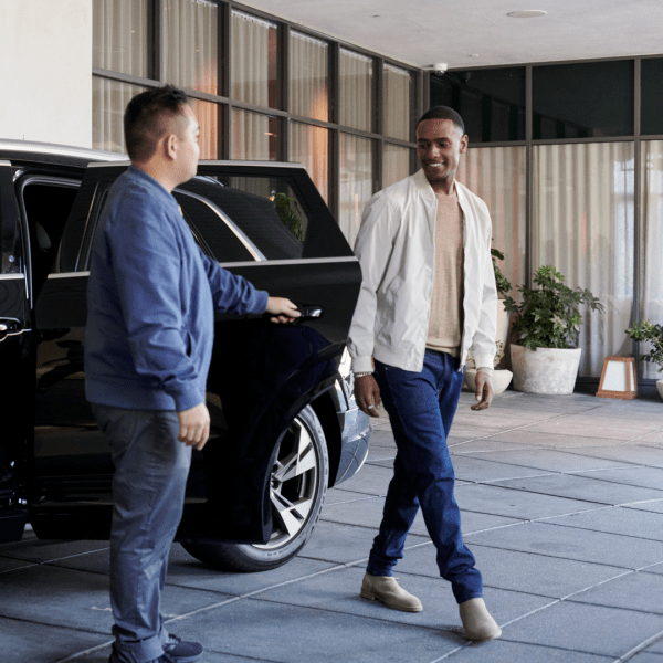 A valet welcomes guest who has just arrived in Audi e-tron house car