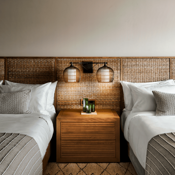 Two large beds with wicker headboards side by side