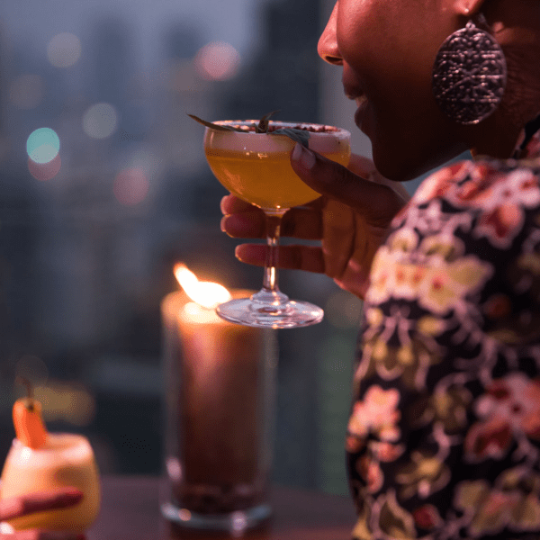 Person sipping a cocktail at night