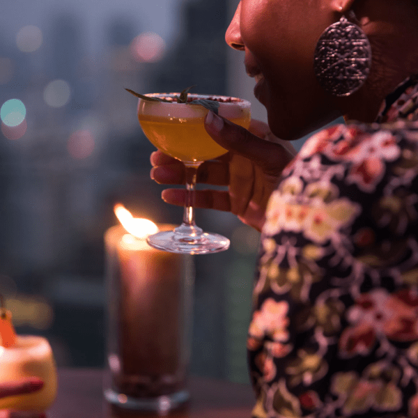 Person sipping a cocktail at night