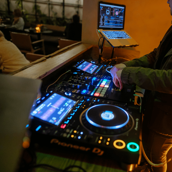 a person DJing, dj, sound board, event