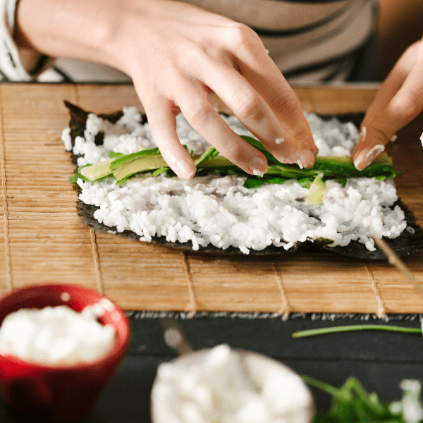 person rolling sushi