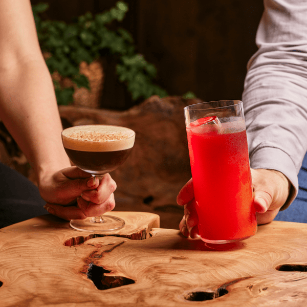 two people holding cocktails