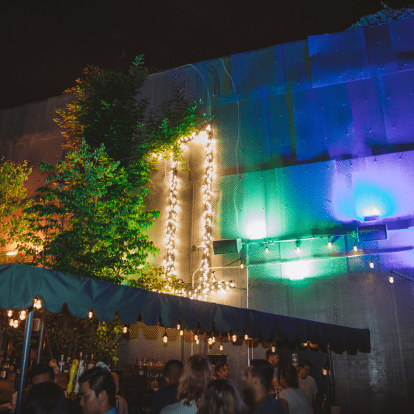 The 1 Hotels brand outlined in lights displayed over an outdoor patio at night