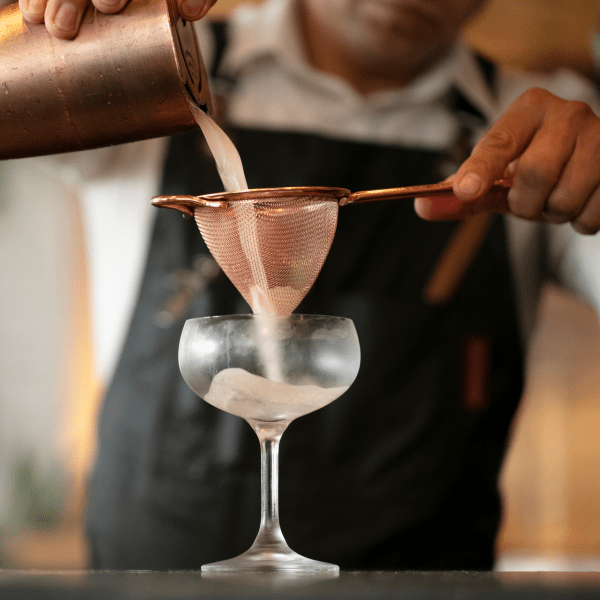 pouring and straining cocktail