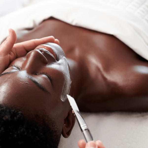 A woman at the spa getting a facial mask