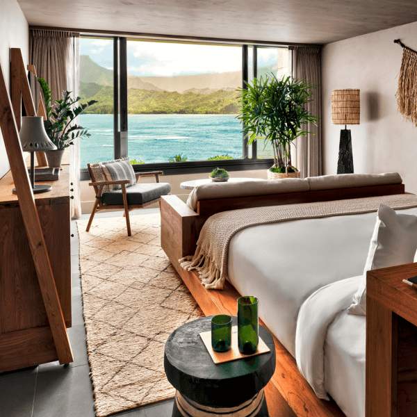 A bedroom with a view of the ocean just outside