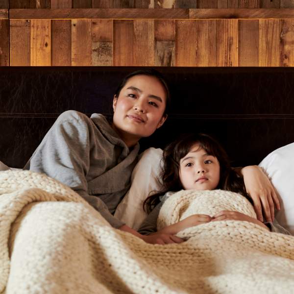 Mother and daughter lounge in their bed