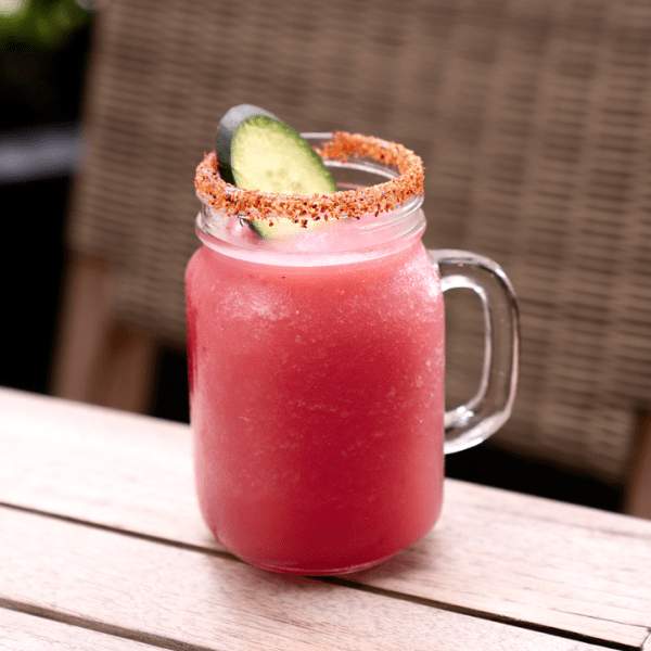 Pink cocktail in a mason jar with a salt rim