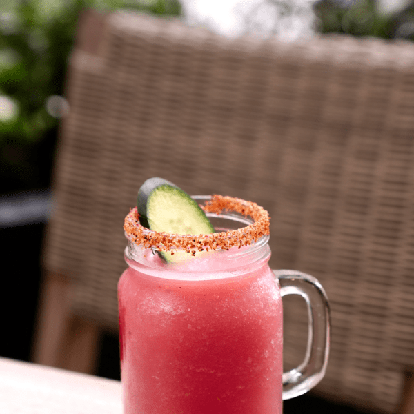 Pink cocktail in a mason jar with a salt rim