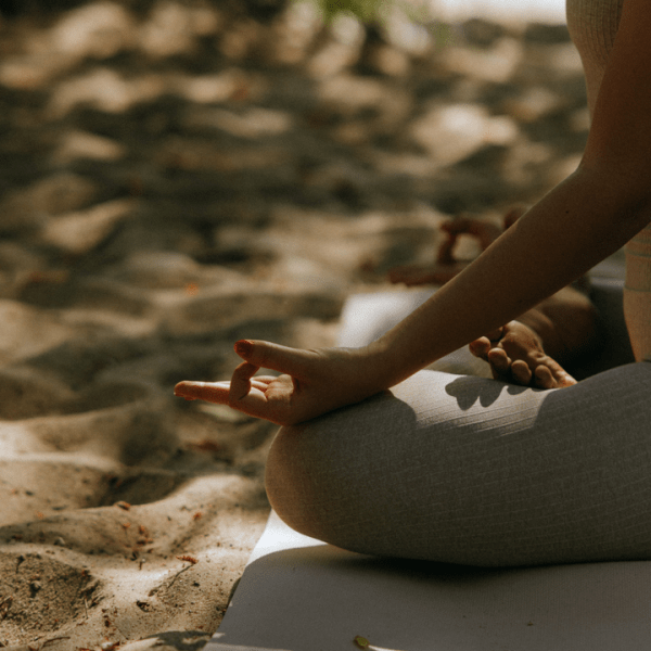 woman sitting in a yoga pose by the water
