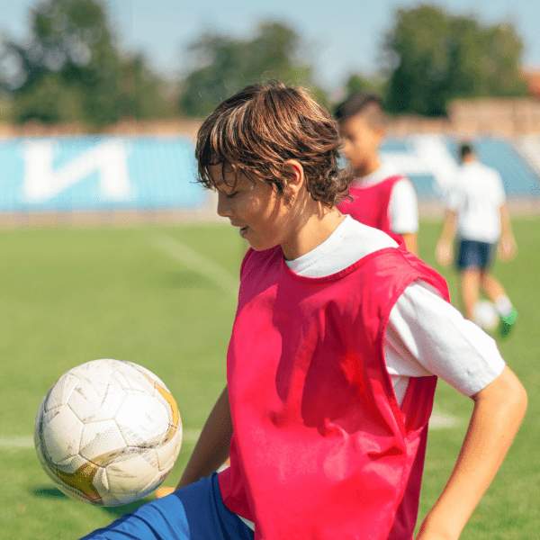 Et barn på en fodboldbane med en fodbold
