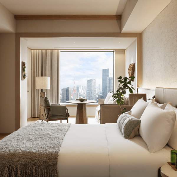 Modern bedroom with large windows, a tea table, chairs & couch