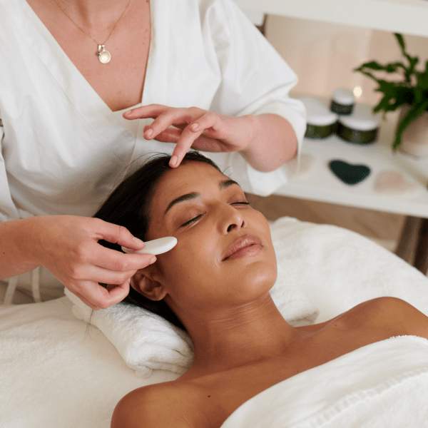 A woman smiles while receiving a massage at a spa.