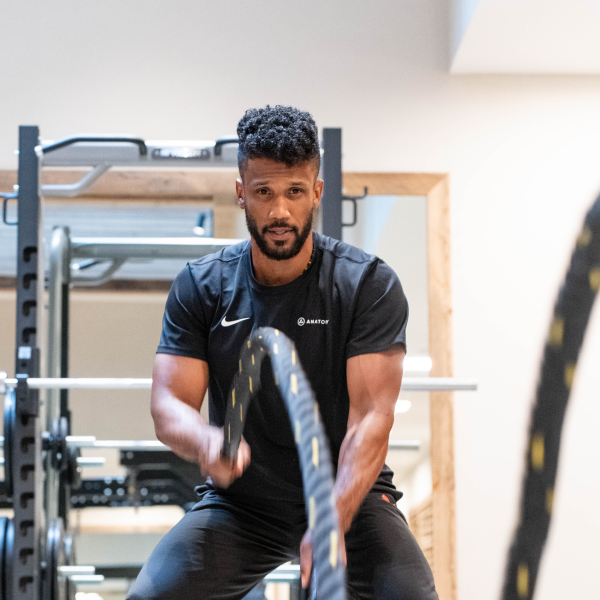 Trainer at Anatomy using Battle Ropes to train