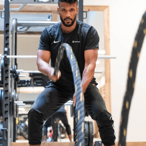 Trainer at Anatomy using Battle Ropes to train