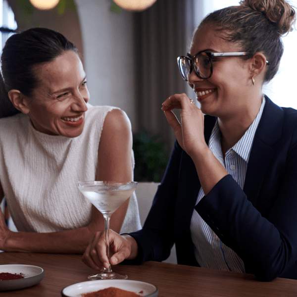 Two people chatting at a bar