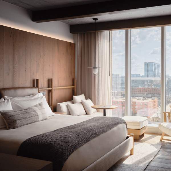 As janelas amplas permitem a entrada de muita luz natural, banhando a cama king size com o sol