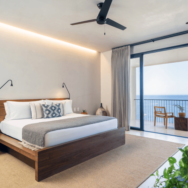 A large king size bed with views of the ocean from a private patio