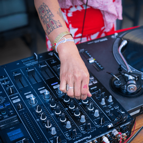A DJ tuning his mixers controls