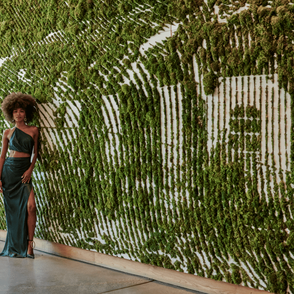 Woman stand in front of the 1Hotel West Hollywood plant sign 