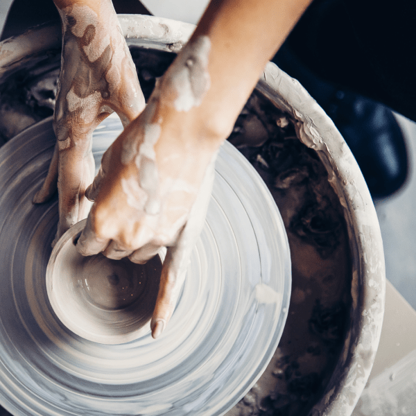 hands shaping pottery on a pottery wheel