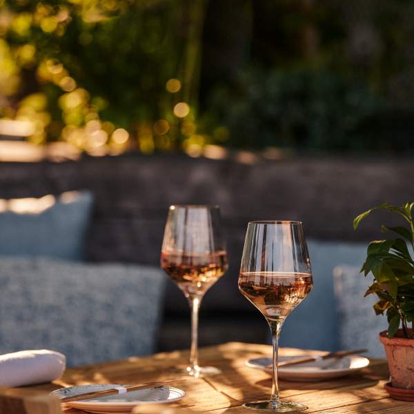 Two rose wine glasses on a wooden table at Harriet's Rooftop