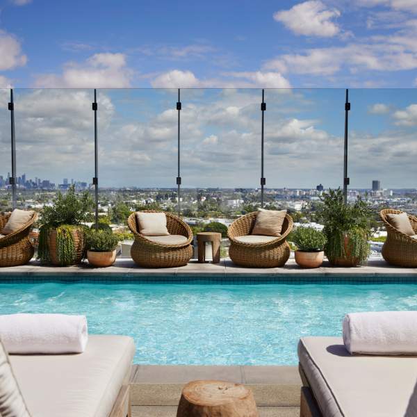 Vue de la piscine sur le toit depuis deux chaises longues au bord de la piscine.